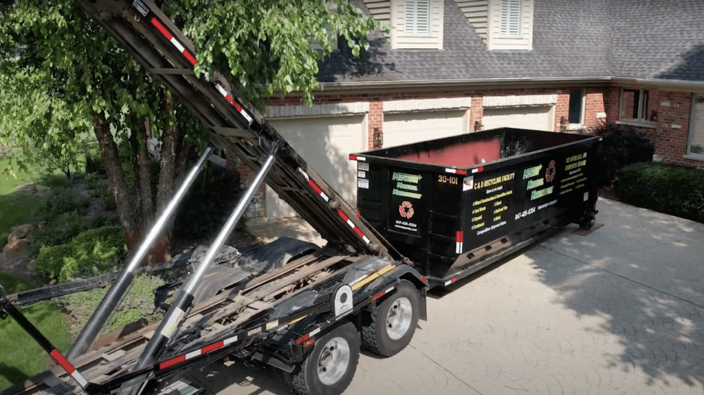 MMM Dumpsters rental dumpster placed beside a house for a residential cleanout.